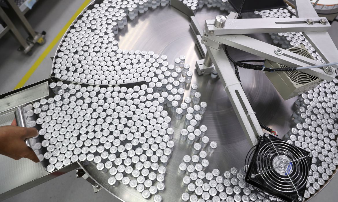 An employee puts on an equipment vials containing CoronaVac, Sinovac's vaccine against the coronavirus disease (COVID-19), at Butantan biomedical production center in Sao Paulo, Brazil January 22, 2021. REUTERS/Amanda Perobelli