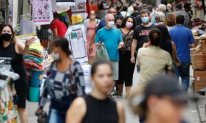 pessoas transeuntes pedestres mascara centro cidade comercio movimento economia habitantes