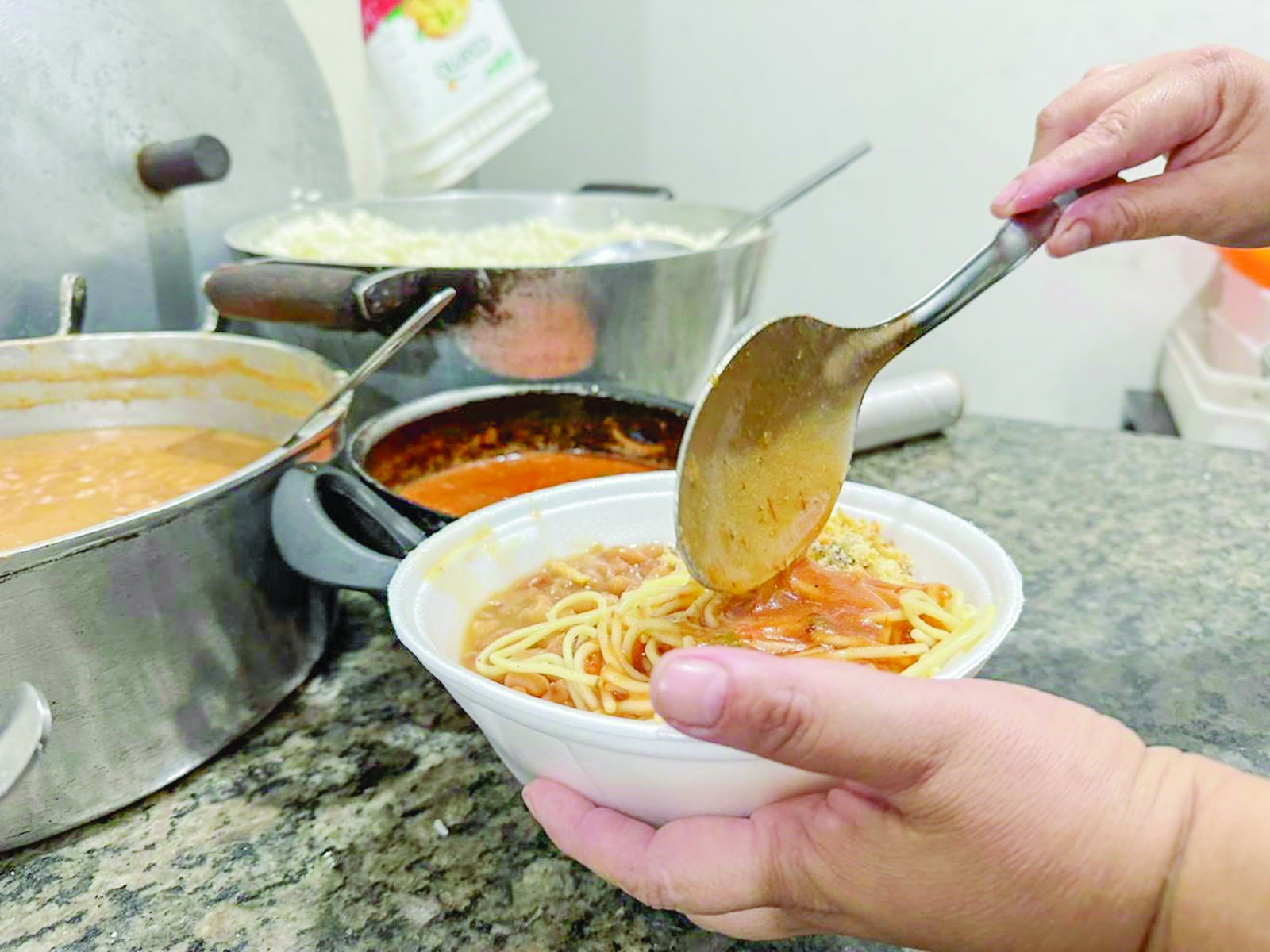 Foto:Funcionária de
marmitaria em Campo
Grande servindo
refeição/Marcos Maluf