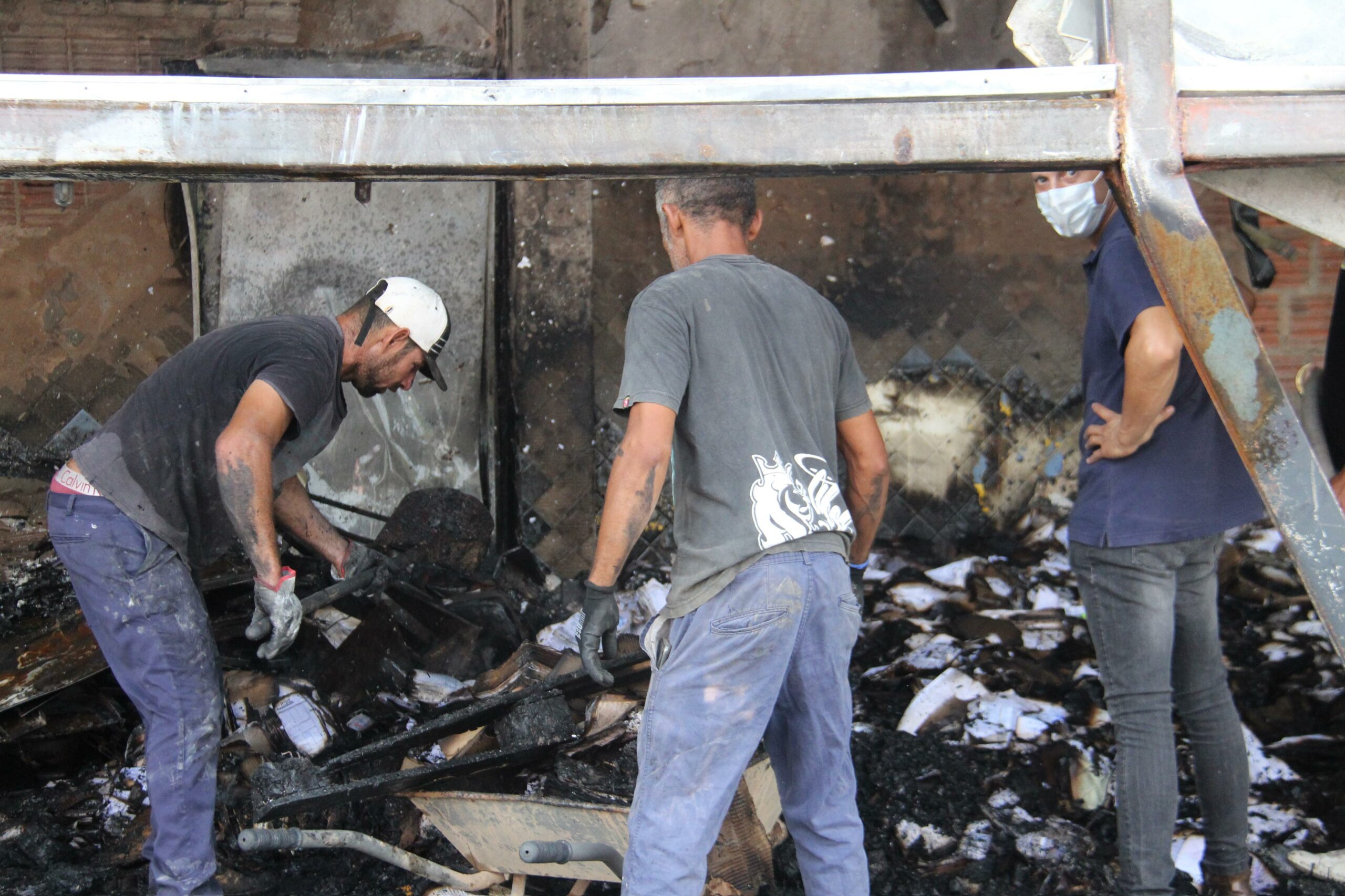 Funcionários fazendo a limpeza após o incêndio (Foto: Roberta Martins )