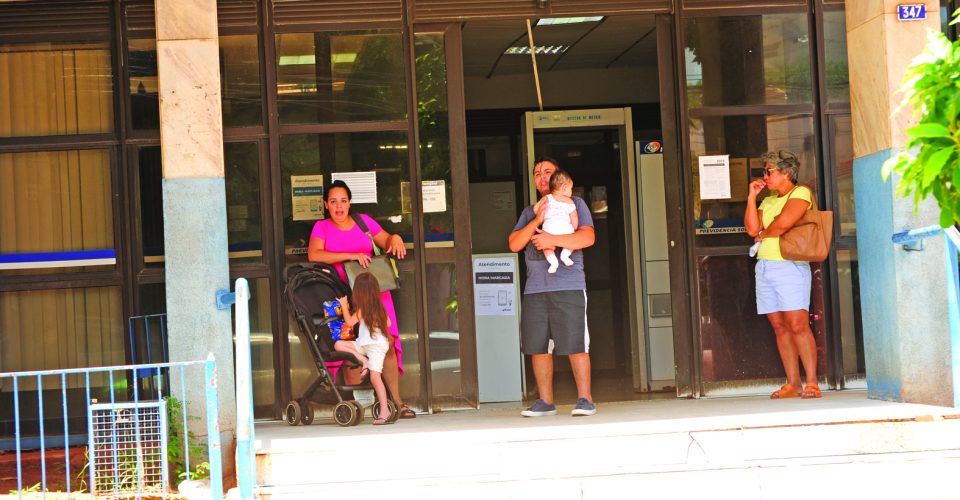 Casal com crianças em frente àgência do INSS, em Campo Grande - Foto: Nilson Figueiredo