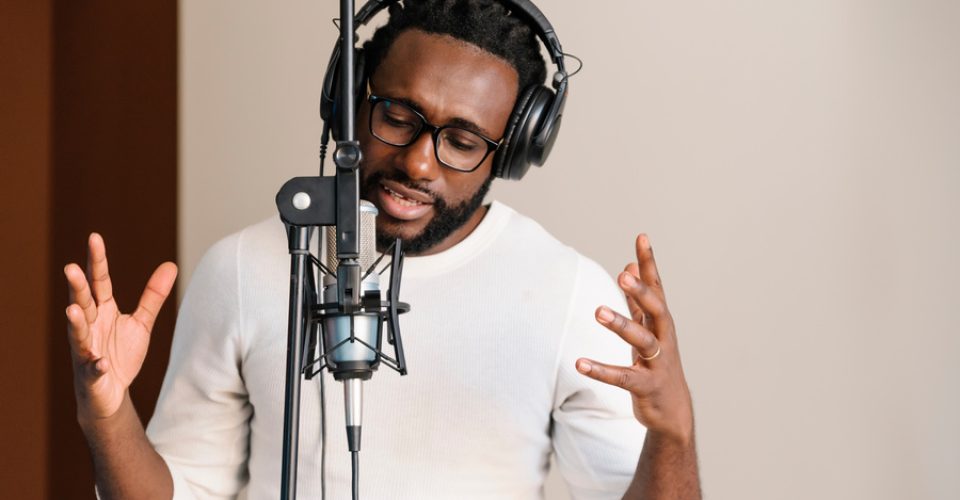 African young man singing on musical studio.