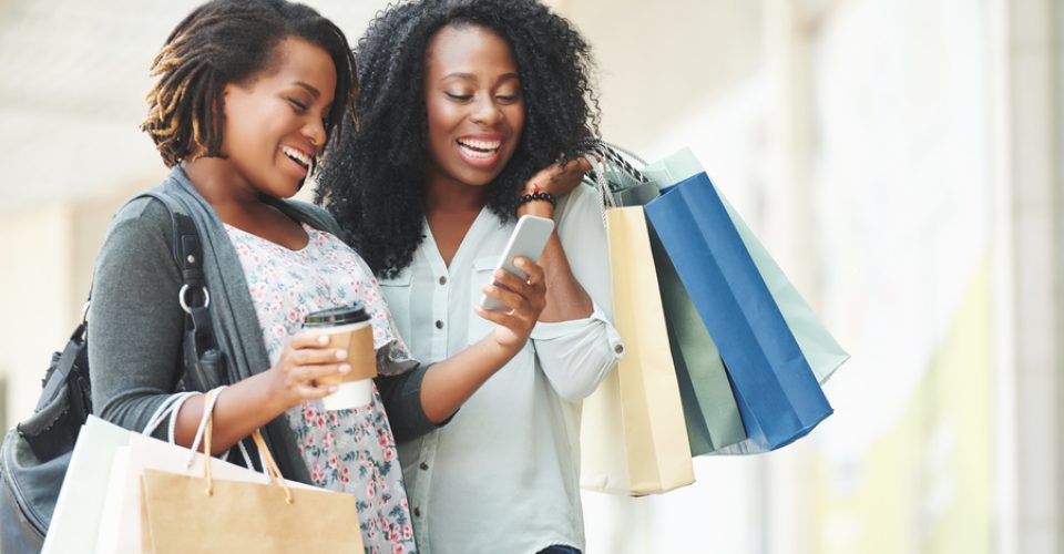 Happy African-American women reading message on smartphone