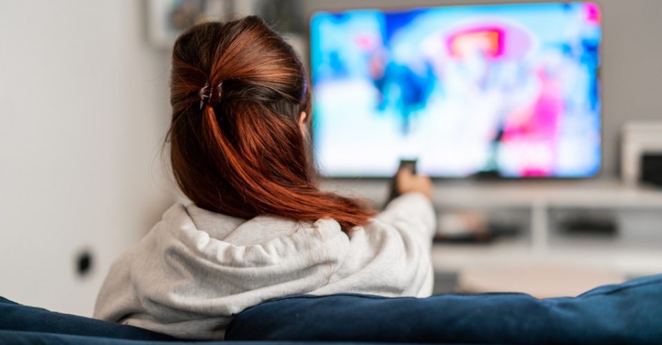 Girl watching tv programs on the sofa