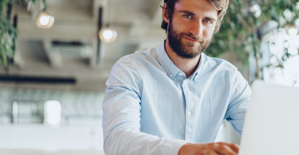 Businessman in shirt working on his laptop in an office. Open space office