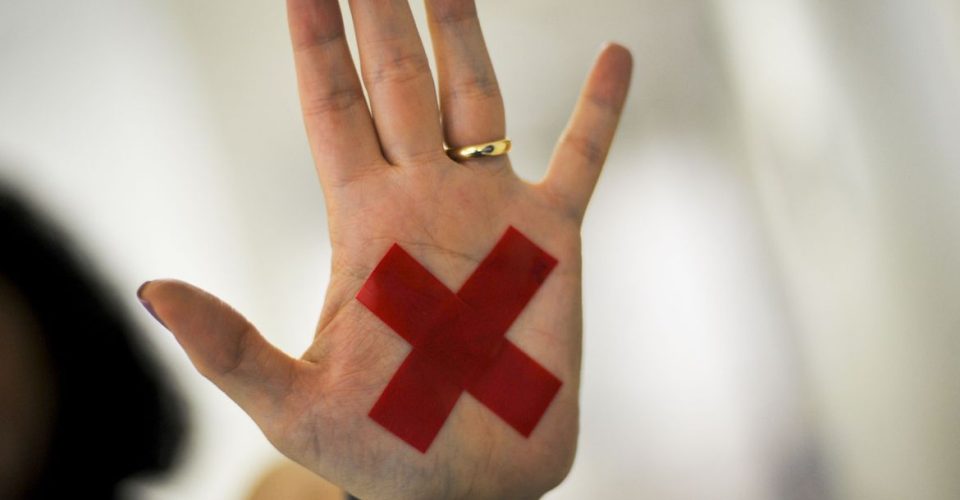 O sinal “X” feito com batom vermelho (ou qualquer outro material) na palma da mão ou em um pedaço de papel, o que for mais fácil, permite que a pessoa treinada reconheça que aquela mulher foi vítima de violência doméstica e, assim, acione a Polícia Militar. Foto: Agência Brasil